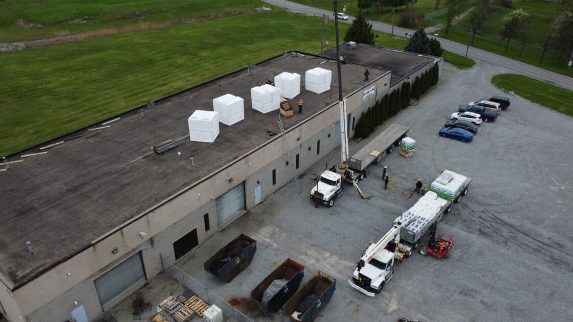Aerial view of Videl Roofing loading insulation materials onto a flat commercial roof in Welland, Ontario as part of a 10,800 sq. ft. replacement project.