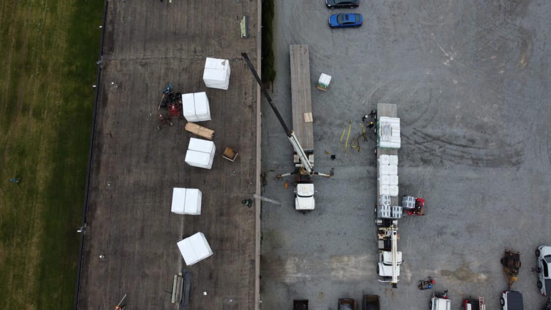 Staged Roofing Materials and Crane Setup for Commercial Roof Replacement in Welland