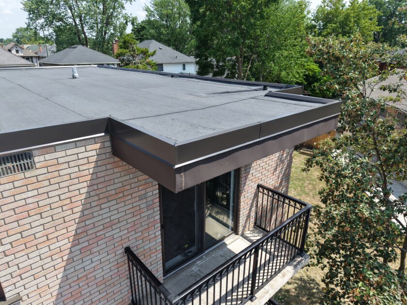 Close-up of balcony corner showing clean lines and waterproof finish on apartment building’s new two-ply roof.