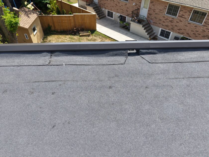 Series of external scuppers installed along apartment building roof edge to improve water flow.