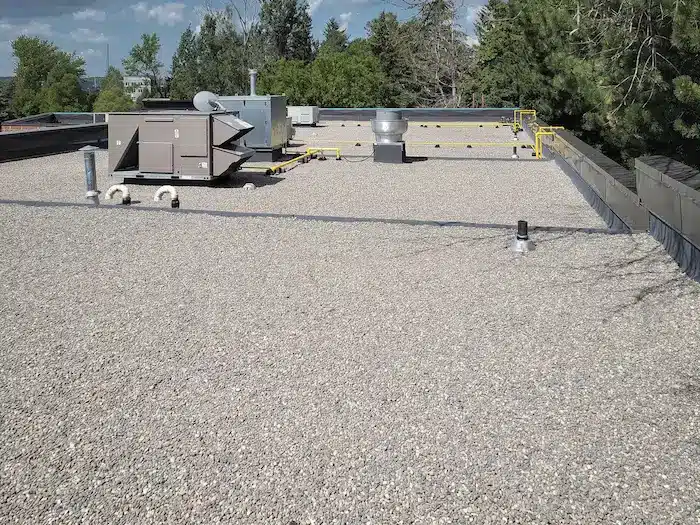 Replaced roof drains and vents with new 4-ply BUR membrane on a commercial flat roof in Barrie, Ontario