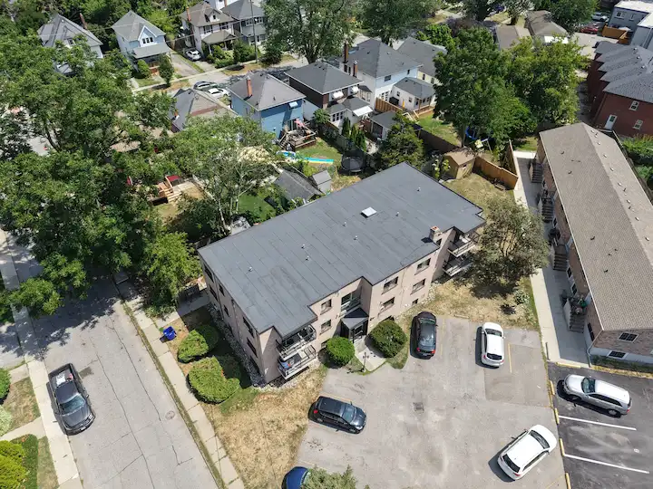 Detailed view of apartment building roof replacement showing corner finish with two-ply modified bitumen and flashing.
