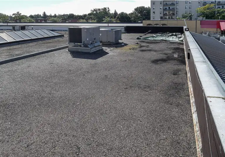 Videl Roofing crew installing new roof drains to eliminate ponding during a flat roof replacement on Scott Street in St. Catharines