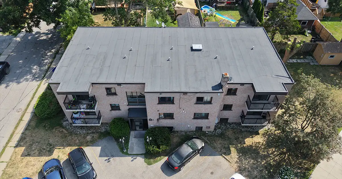 Front-facing aerial view of 1970s apartment building roof replacement featuring new two-ply modified bitumen system.