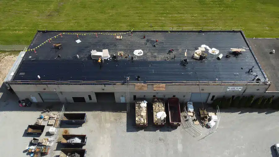 Crew applying base sheet membrane on commercial flat roof in Welland