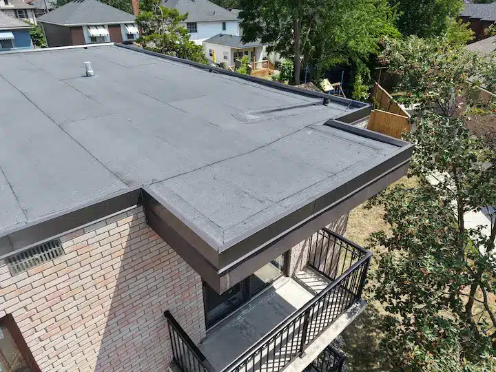 Close-up of balcony corner showing clean lines and waterproof finish on apartment building’s new two-ply roof. 