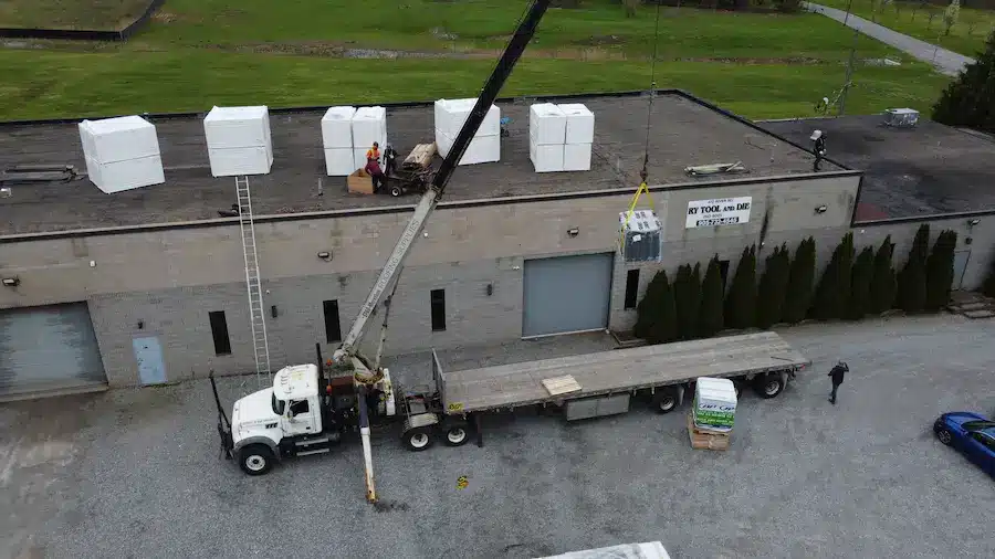 Aerial view of Videl Roofing loading insulation materials onto a flat commercial roof in Welland, Ontario as part of a 10,800 sq. ft. replacement project.