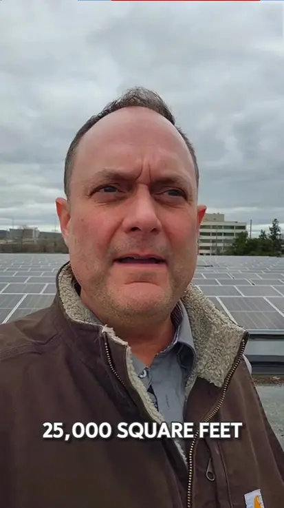 Kirby Hewines inspecting ponding water on a commercial flat roof in Ontario, explaining the role of slope and tapered insulation in preventing long-term damage